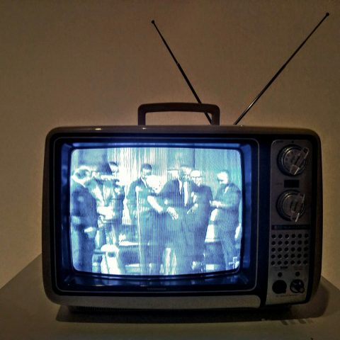 black crt tv turned on on white table