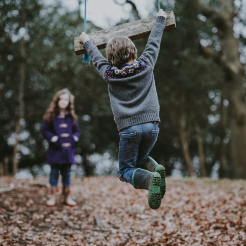 boy holding on swing bench